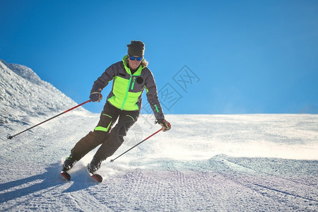 下坡在滑雪地区斜上的高山快乐者图片