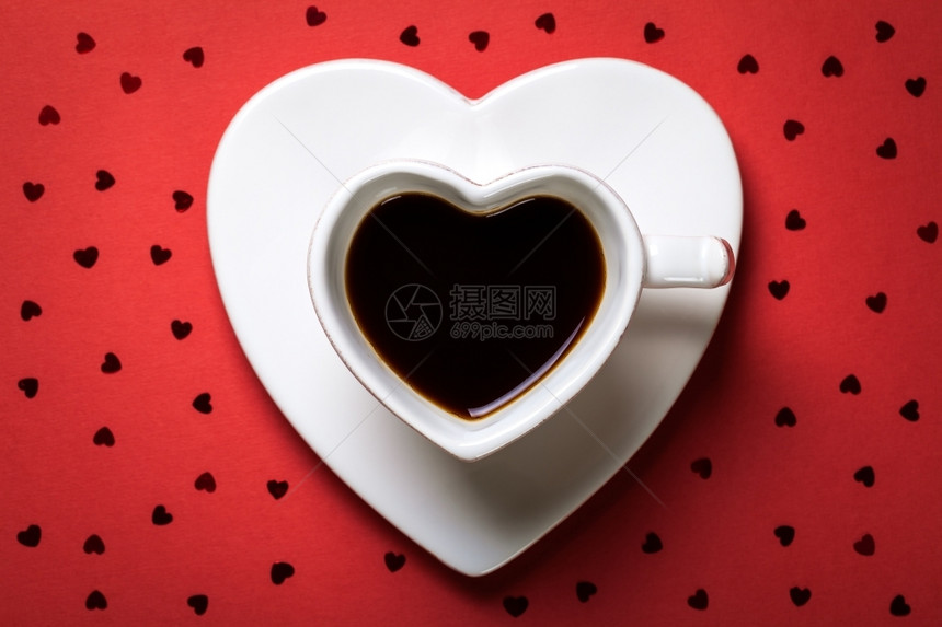红色的纸背景咖啡杯在红纸背景上以心形状的咖啡杯卡布奇诺子图片