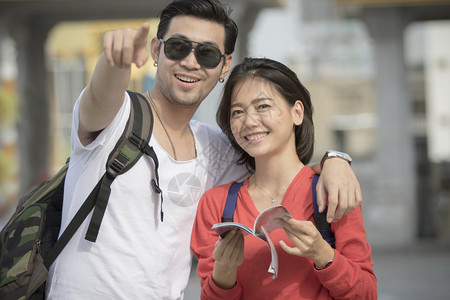 年轻亚洲人的背包男女快乐旅游目地吸引人女背景图片