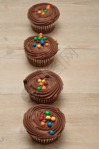 不良巧克力杯饼霜冻和彩色糖果装饰的巧克力蛋糕美食诱惑图片