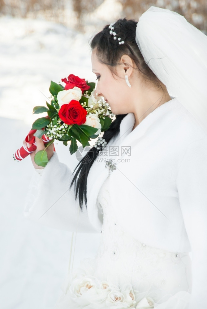 女新娘的肖像用一束鲜花穿着婚纱美丽华的图片