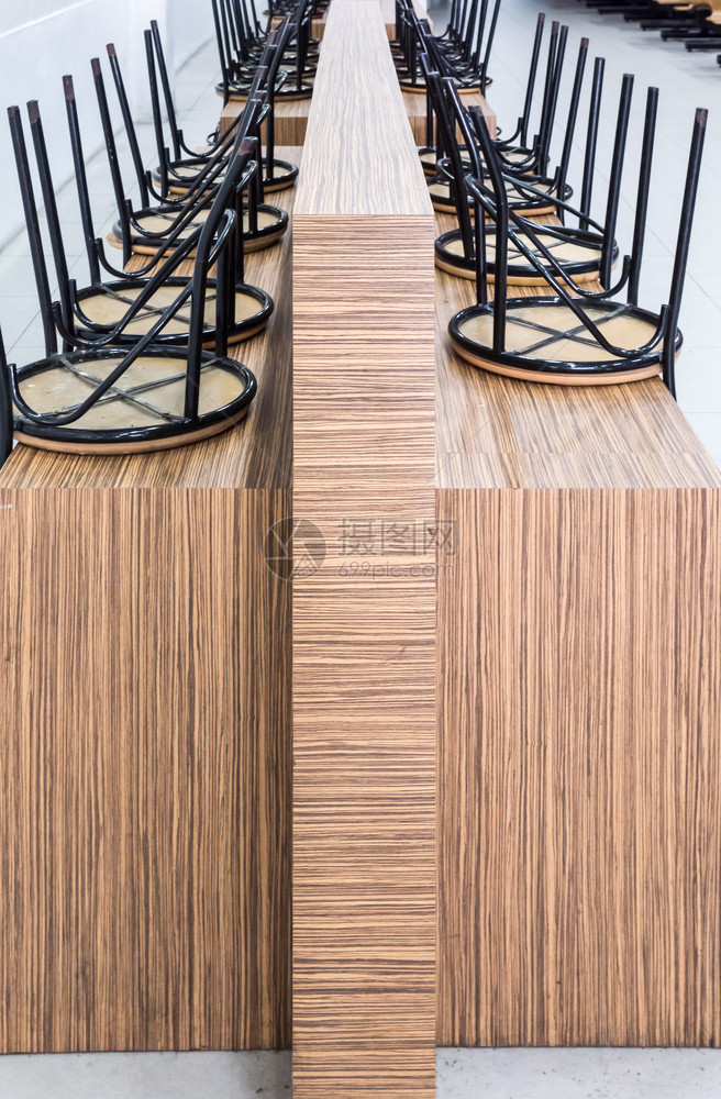 餐厅关门后金属椅子排在木制桌上以保持内部的优质家具图片