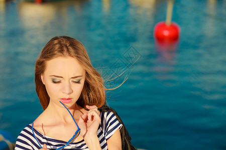 外部月夏放松概念穿蓝心的肖像女孩戴着蓝色心型太阳眼镜在码头外享受夏风图片