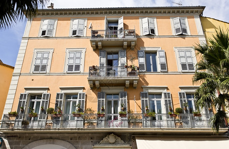 美丽的古老阳台配有地中海建筑风格的多彩花朵和木制门建筑的老里维埃拉图片