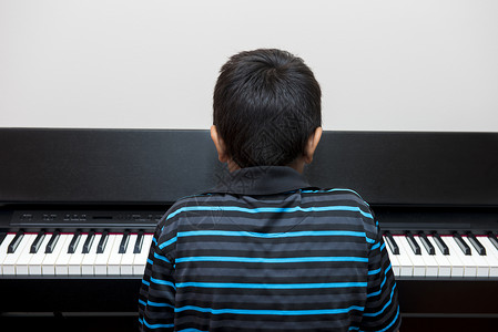 弹钢琴的男孩背影图片