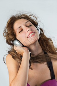 无线的听音乐美丽女孩形象耳机令人兴奋的图片