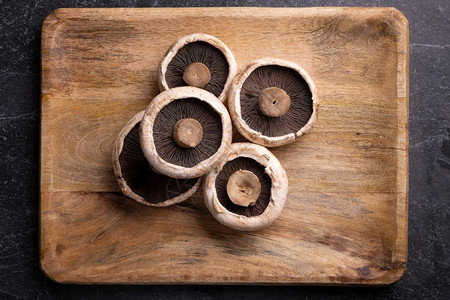 饮食超过大理石桌上木托盘的5个软骨蘑菇有质感的背景图片