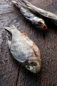 渔业啤酒塔兰卡盐咸干河鱼的棕色木头背景图片