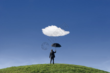 晴天松弛商人在山上拿着雨伞在一朵云下弃图片