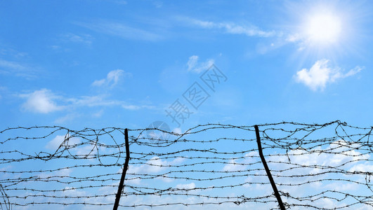 边界复制以铁丝钢墙抵挡蓝天空和阳光作为希望的自由监狱和希望概念移民图片