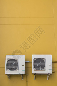 黄色墙壁背景的空调压缩机器电的护发素屋图片
