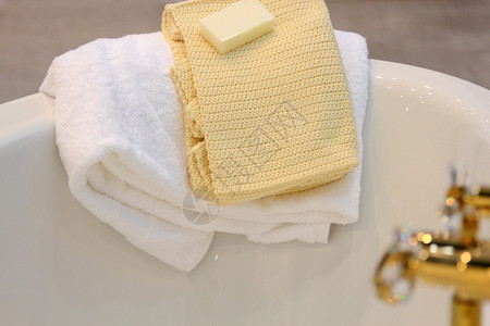 细节龙头毛巾和一块肥皂都躺在浴缸边上绒布图片