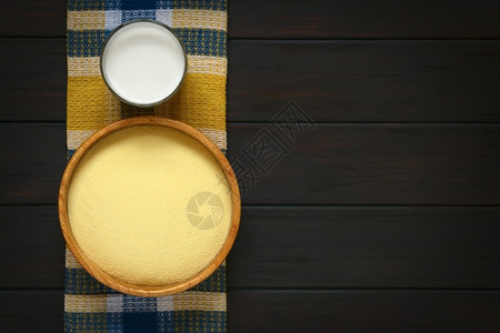 水平的木制质碗中原生血清片头照布上装着一杯牛奶用带自然光的黑木拍到照片甜的背景图片
