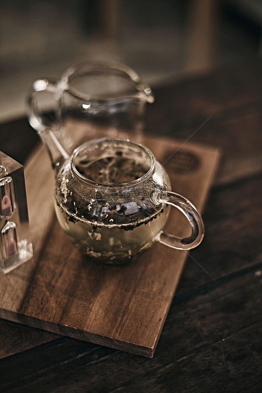 早餐有机的植物以木制背景的玻璃茶壶在木制背景的玻璃茶壶中选择焦点茶图片
