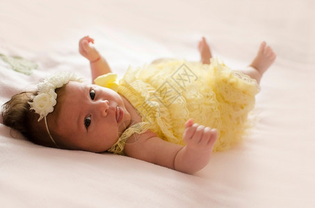 新生健康可爱的两个月大女婴躺在粉红色毯子背上有趣的婴儿高清图片素材