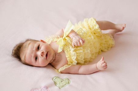 说谎盯金发女郎可爱的两个月大女婴躺在粉红色毯子背上图片