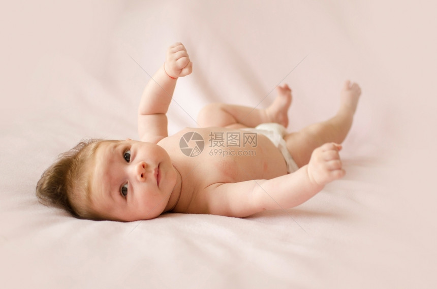 说谎老的可爱两个月大女婴躺在粉红色毯子背上黄的图片