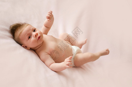微笑可爱的两个月大女婴躺在粉红色毯子背上柔软的部美丽的高清图片素材