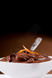 奶油美味的巧克力慕斯在一个有橙色芝士的白碗里摩丝空气图片