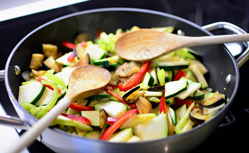 蔬菜翻炒搅拌烤新鲜的切开茄子苏奇尼和加木勺的锅里胡椒粉准备健康的食物辣椒高清图片素材