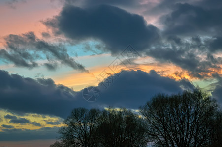 极好的蓝色橙在五颜六日落天空背景大乌云在树剪影五颜六色云彩在晚上天空图片