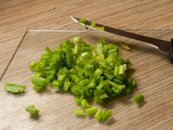 在厨房切削板上绿洋葱碎色片木板白色的图片