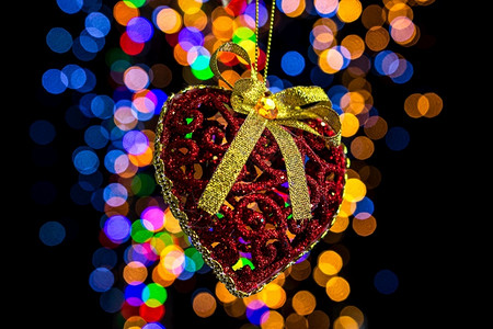 季节喜庆的丝带举行圣诞装饰活动对抗bokeh灯光背景图片