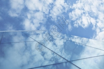 外部的玻璃摩天大楼反射中的云和蓝天空反射公司的金融图片