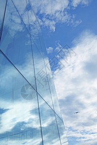 玻璃摩天大楼反射中的云和蓝天空反射墙闪亮的商业图片
