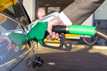 燃料消耗喷嘴车站在加油用煤气或汽装满车的Arrsquos手保持背景