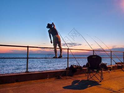 晚上轮廓日落时从码头捕鱼的人松弛图片