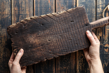食谱手握木制剪板挂在生锈的木制桌子上方手举木制砍板菜单棕色的图片