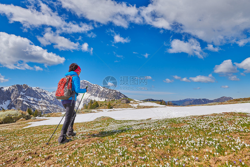 休息北欧的一个女人走在山地草上带着花椰子朵番红图片