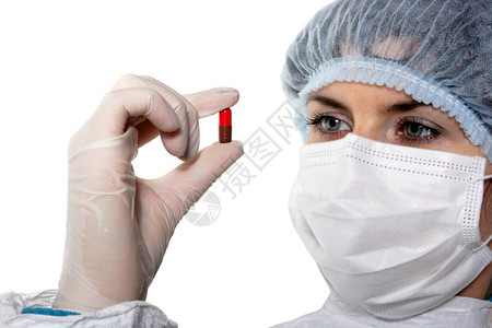 手里握着红色药丸的医生图片