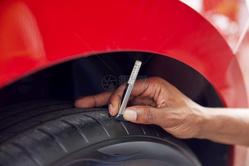 使用高盖格检查汽车轮胎上的轨迹人近距离检查维护人们测量图片