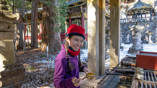 传统竹子站在日本净水盆地的Tween女孩洗背景