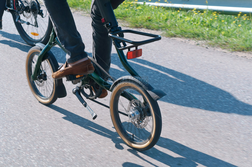 男生公园娱乐在路上骑自行车带小轮子的自行车带皮传动的自行车带小轮子的自行车带传动的自行车在路上骑自行车图片
