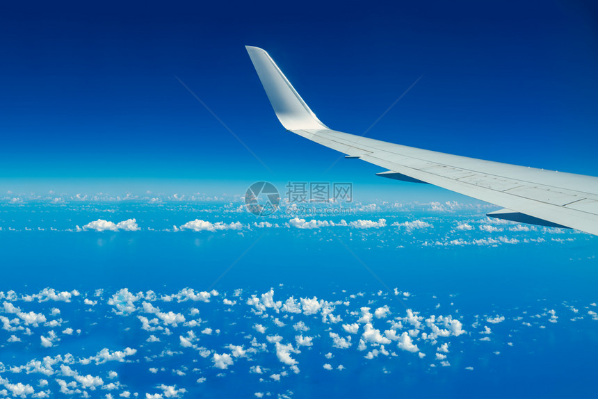 飞越蓝天和白云空的飞机翼在行时透过机窗仰望可视空间商业的美丽看图片