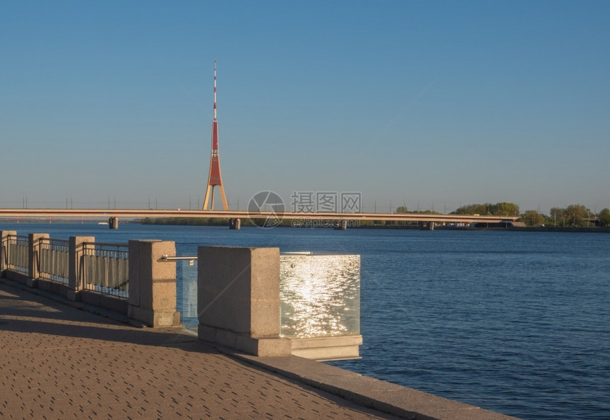 长廊春天观看位于RIga的DaugavaPromenade在阳光明媚的春夜阳光和闪亮的水从玻璃阳台反射到南部水桥和Riga无线电图片