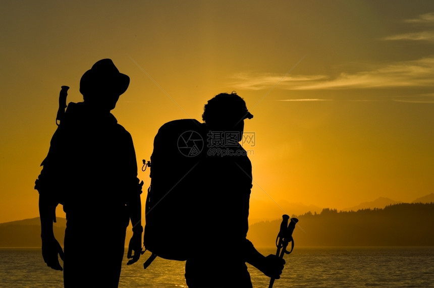 两个探险家的休光月仰慕在湖上日落的光芒在山丘和森林背景中陵棍子冒险家图片