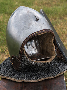 历史中世纪主题木桌上的银和金属骑士盔甲古董背景图片