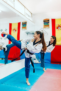 个人的腰带有两年轻妇女在一培训中心里练习泰拳道健身房背景图片