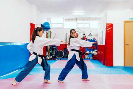 老师中央韧有两个年轻妇女在一培训中心里练习泰拳道高清图片