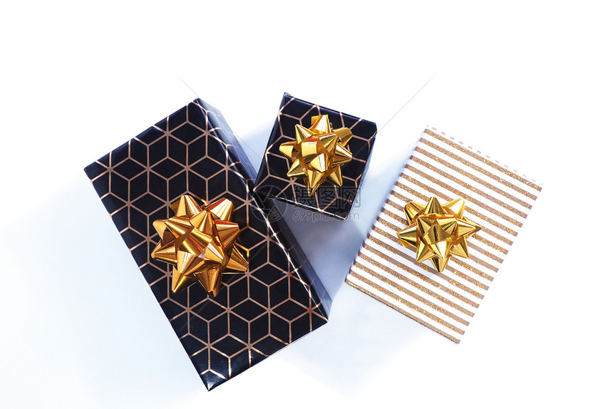 3个礼品盒是黑色的有几何图案金弓和黑色的白光亮的盖子和弓白色背景上的单状银卡片菱形图片