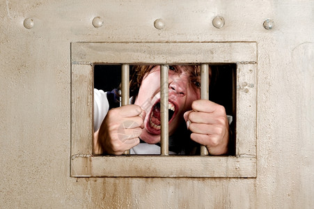囚犯嘴监狱里的人疯了抓着牢房的栅栏看着狂犬病大声叫喊无法控制单身的背景图片
