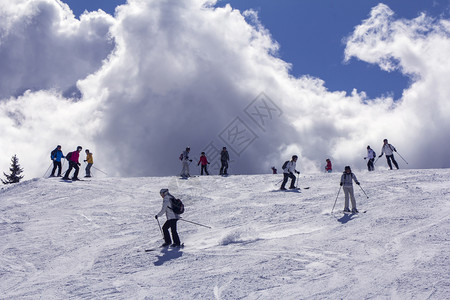 臭鼬阳光旅游山边的滑雪者在背景光线下图片