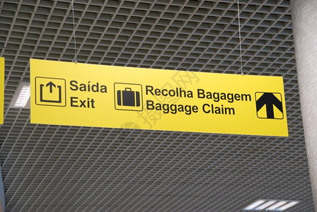 挂在天顶上的一个国际机场黄色出境和行李报销标牌游客旅行黄色的图片