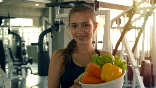 在健身房拿着水果的女人图片