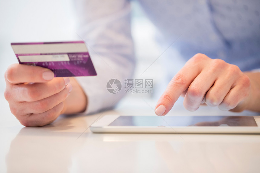 妇女使用信卡在数字平板电脑上购物的特写人们药片打字图片