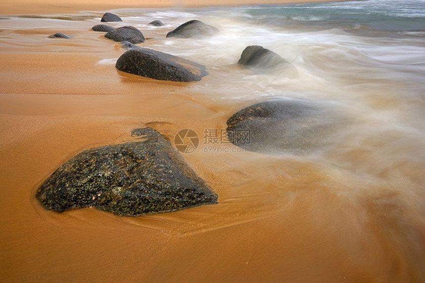 流动海洋中的岩石日出圆形图片
